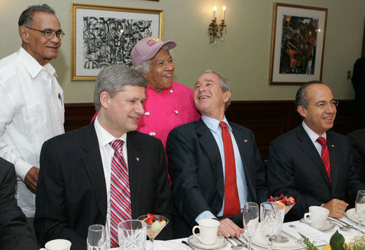 US presidents George W Bush and Bill Clinton dining in New Orleans restaurant with guests during official visit