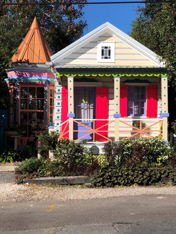 olorful New Orleans shotgun house with vibrant paint and decorative trim representing historic residential architecture