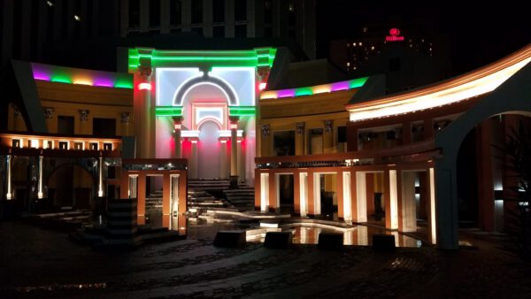 Piazza d’Italia illuminated at night in New Orleans featuring colorful postmodern architecture and Italian-inspired arches