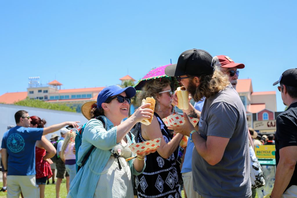 Jazz Fest attendees enjoy sausage poboys from Vaucresson’s Sausage Company. Photo to be featured in The Big Book of Po’boy.