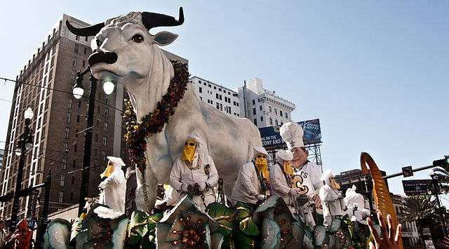 The Boeuf Gras rolls down Canal Street in New Orleans during the Rex parade in 2010. The “fatted ox” is surrounded by krewe members dressed as butchers and bakers. Photo by Andrea Ciambra.