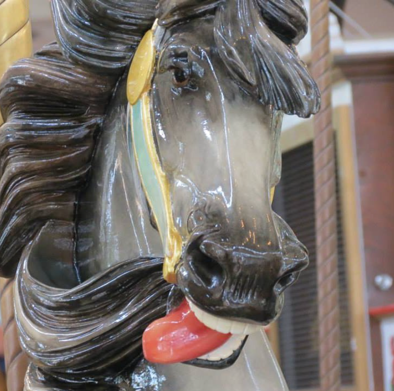 Photo of the Carousel Gardens merry-go-round, with Charles Carmel’s signature “lolling tongue.” Courtesy of Wiki Images.