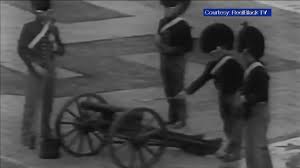 Several Battle of New Orleans reenactors gather around a cannon during the Super Bowl IV halftime show.